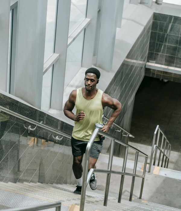 Man performing a controlled strength exercise in a modern gym.